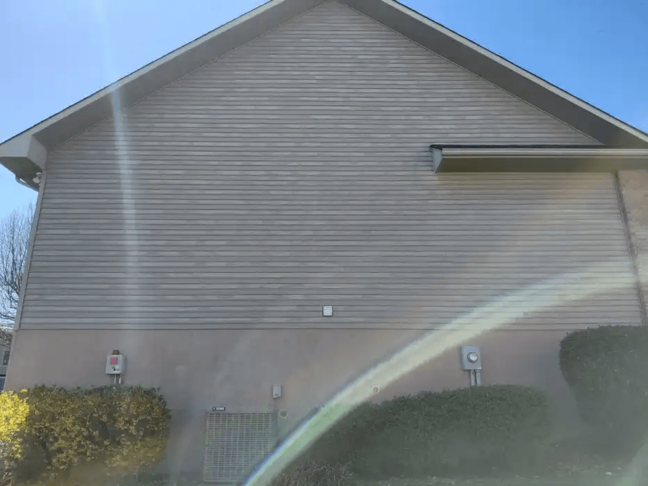 Clean vinyl siding and foundation on a residential home after exterior washing
